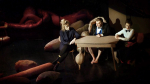fot. Dorota Awiorko / [Przy stoliku siedzą trzy osoby. Po środku mężczyzna, po jego obu stronach kobiety. Wokół są rozrzucone poduchy w różnych kształtach i rozmiarach. Tło ciemne.]