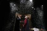 fot. Dorota Awiorko / [Na scenie stoi  dwóch mężczyzn w stylizowanych na renesansowe strojach. Cała przestrzeń jest wypełniona opadającym, gęstym, sztucznym śniegiem.]